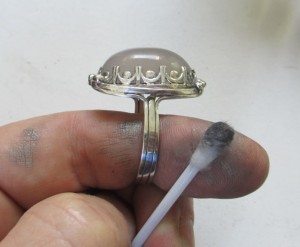 cleaning jewelry with a cotton swab soaked in alcohol
