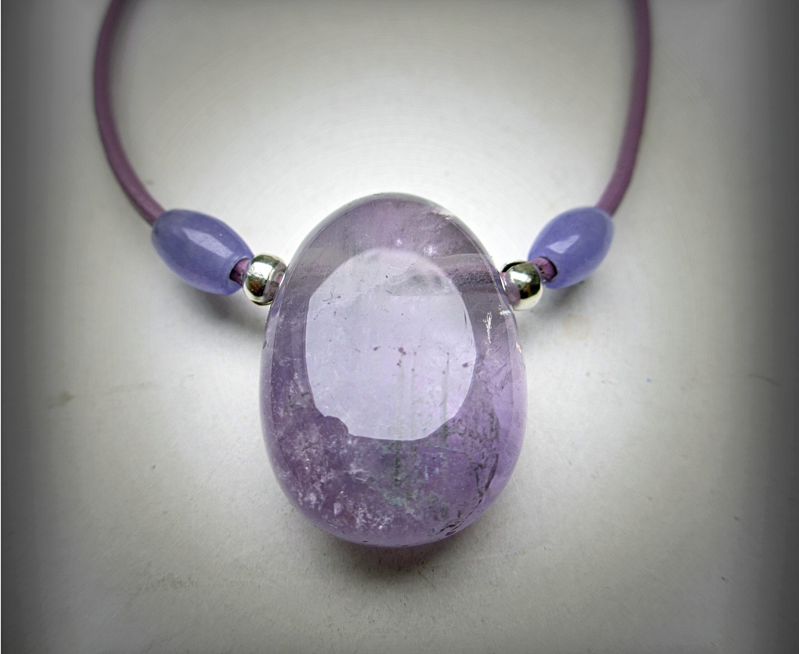 Huge chunky amethyst necklace, a 38 mm tumbled amethyst sided with 2 smaller amethyst beads and silvery decorative elements, purple leather cord 55 cm