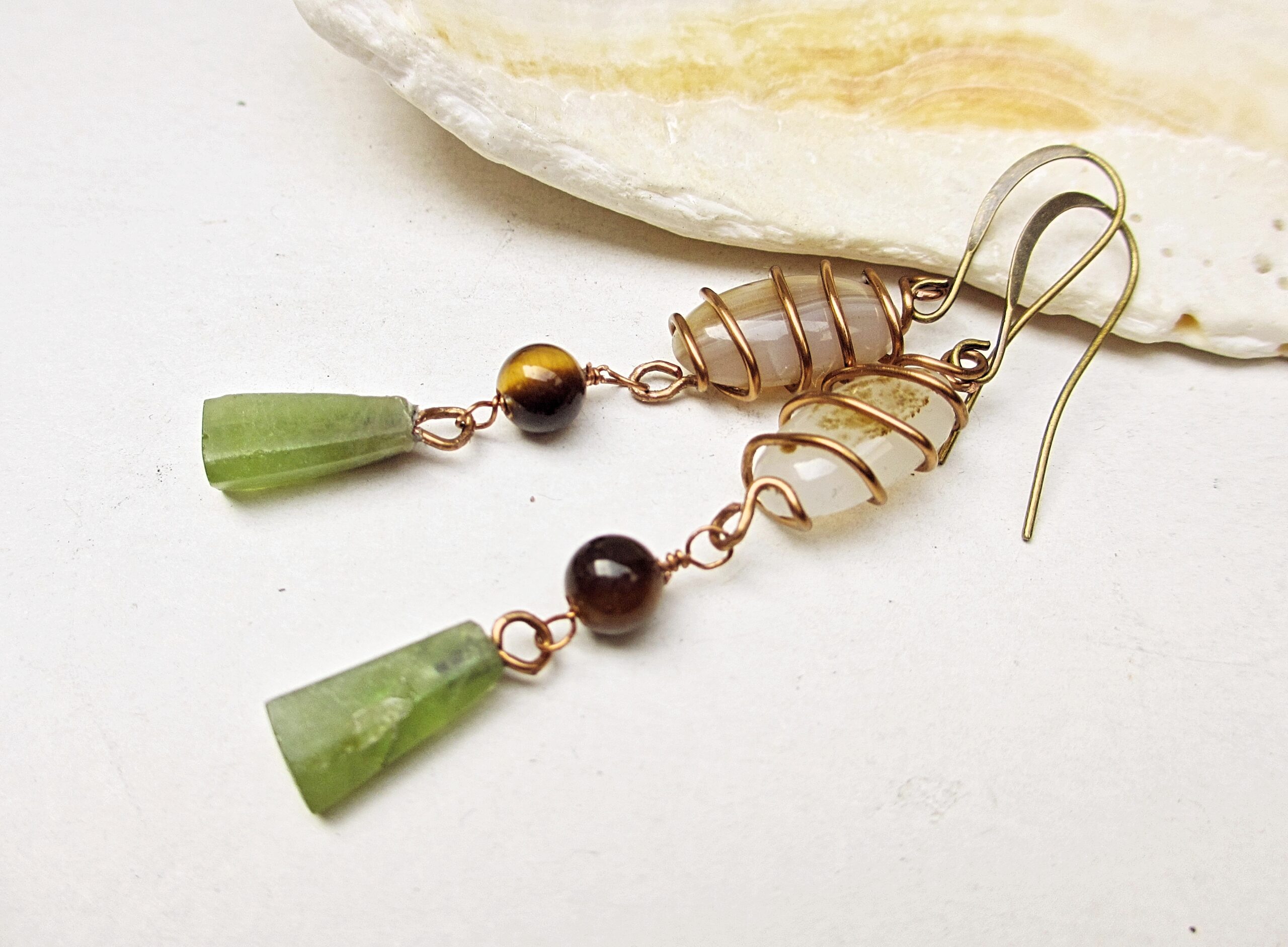 Earthy stone dangle earrings copper. featuring wire-wrapped agate, tiger's eye, and green peridot. Handmade with antiqued copper.